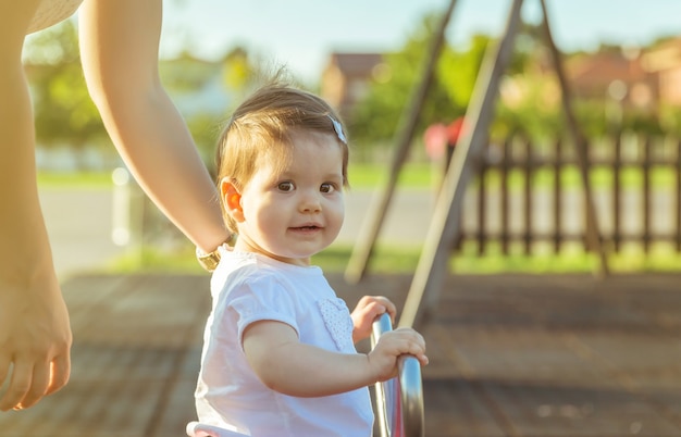 Aanbiddelijk klein babymeisje dat over een wipschommel speelt op het park