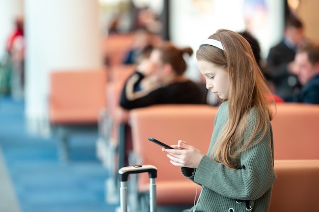 Aanbiddelijk meisje bij luchthaven in grote internationale luchthaven dichtbij venster