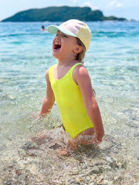 Foto aanbiddelijk meisje bij strand tijdens de zomervakantie