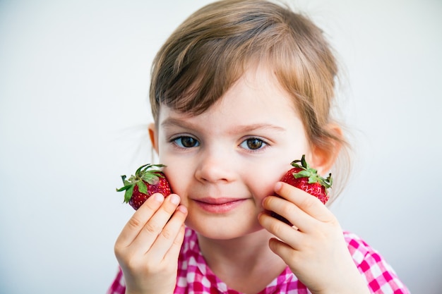 Aanbiddelijk meisje dat aardbeien houdt