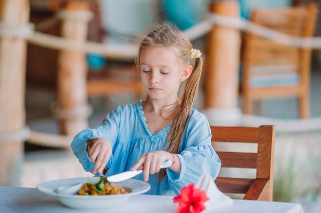 Aanbiddelijk meisje dat diner heeft bij openluchtkoffie