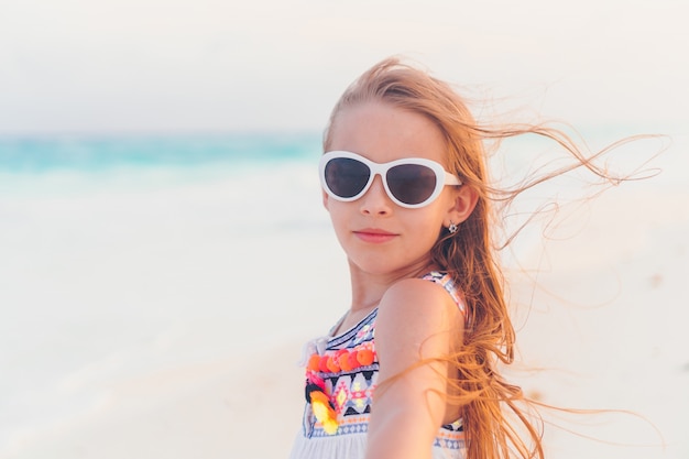 Aanbiddelijk meisje dat langs wit zand caraïbisch strand loopt