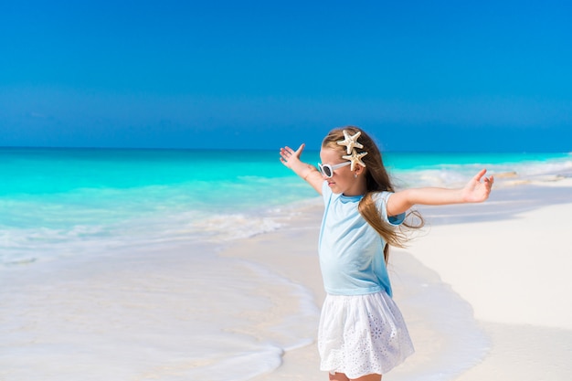 Aanbiddelijk meisje dat langs wit zand Caraïbisch strand loopt