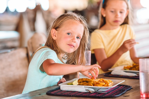 Aanbiddelijk meisje dat ontbijt heeft bij openluchtkoffie