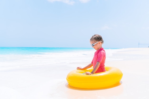 Aanbiddelijk meisje dat op opblaasbaar luchtbed op het strand ontspant