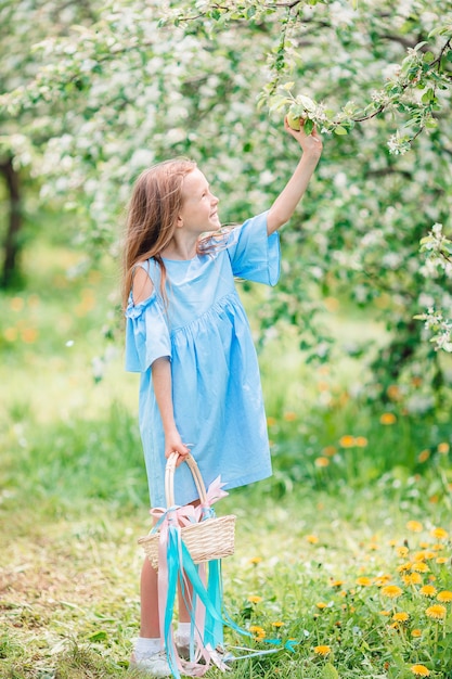 Aanbiddelijk meisje in bloeiende appeltuin op mooie de lentedag