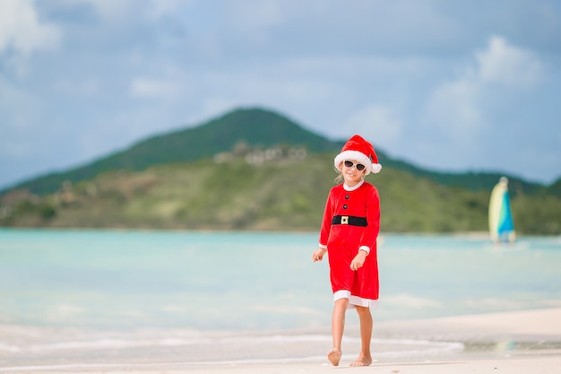 Aanbiddelijk meisje in Kerstmanhoed op tropisch strand