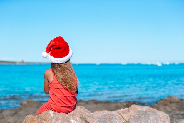 Aanbiddelijk meisje in Kerstmanhoed op tropisch strand