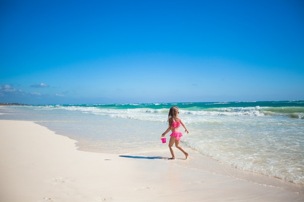 Aanbiddelijk meisje in zwempak die pret hebben bij tropisch Caraïbisch strand