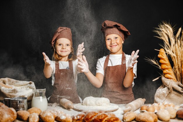 Aanbiddelijk meisje met broer het koken