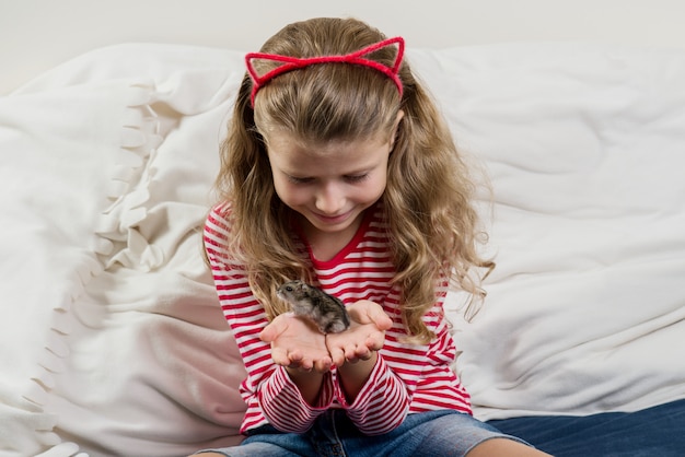 Aanbiddelijk meisje met haar huisdieren kleine hamster