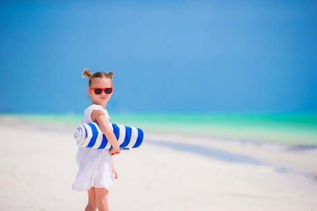 Aanbiddelijk meisje met handdoeken bij tropische vakantie