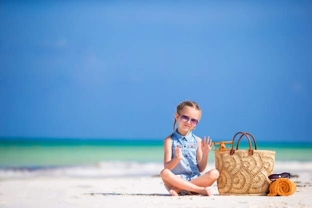 Aanbiddelijk meisje met strandzak en handdoek tijdens de zomervakantie