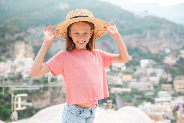 Aanbiddelijk meisje op warme en zonnige de zomerdag in Positano-stad in Italië