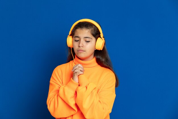 Aanbiddelijk Preteen-meisje met het gele gesturing van Jersey over blauwe muur