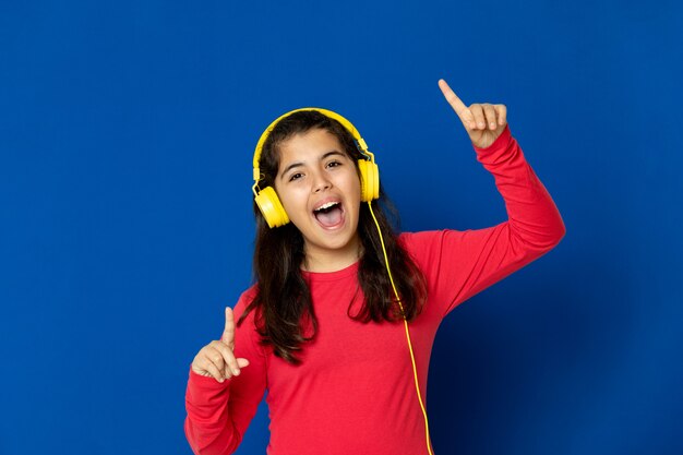 Aanbiddelijk preteen meisje met het rode gesturing van Jersey over blauwe muur