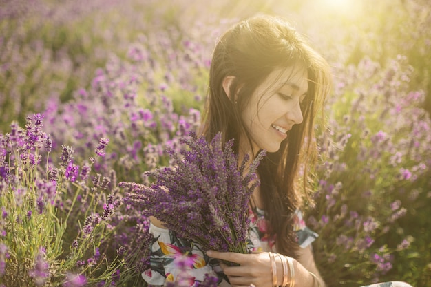 Foto aanbiddelijk romantisch portret van jonge vrouw rond lavendelbloemen.