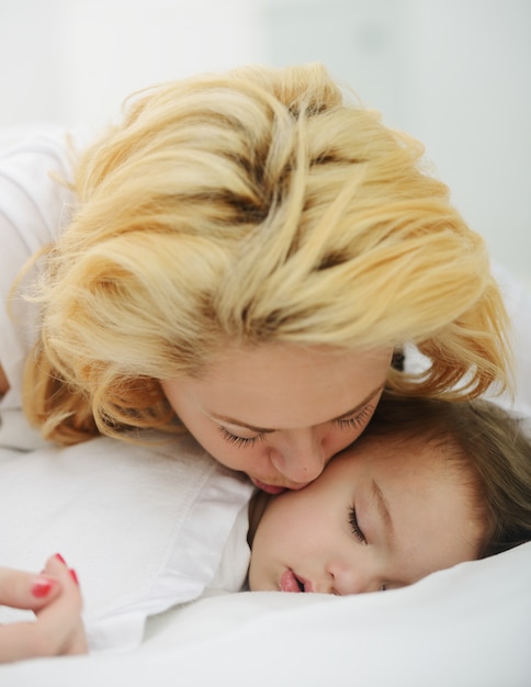 Aanbiddelijke babyjongen met mamma op bed