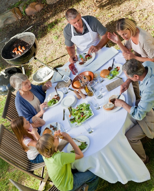 Aanbiddelijke familie die in de tuin eet