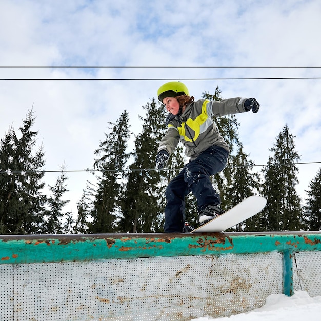 Aanbiddelijke jongen die snowboard berijdt bij skitoevlucht