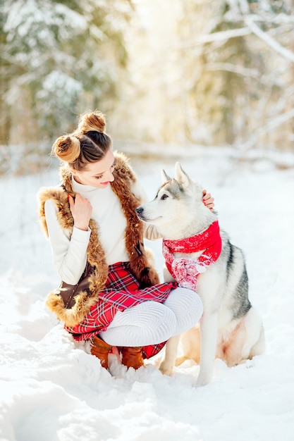 Aanbiddelijke Kaukasische vrouw die tijd doorbrengen openlucht genietend van het ijzige weer met haar schor huisdier. Foto van vrij jonge dame in de winteruitrusting, doordringende blik van een meisje en een hond