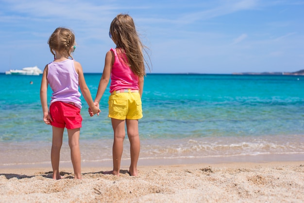 Aanbiddelijke meisjes bij strand tijdens de zomervakantie