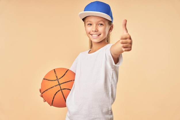 Aanbiddelijke meisjesbasketbalspeler die goedkeuringsgebaar toont