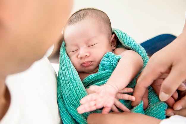 Aanbiddelijke pasgeboren babyslaap in de wapens van vader