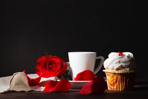 aangename donkere avondscène met koffie en rode roos