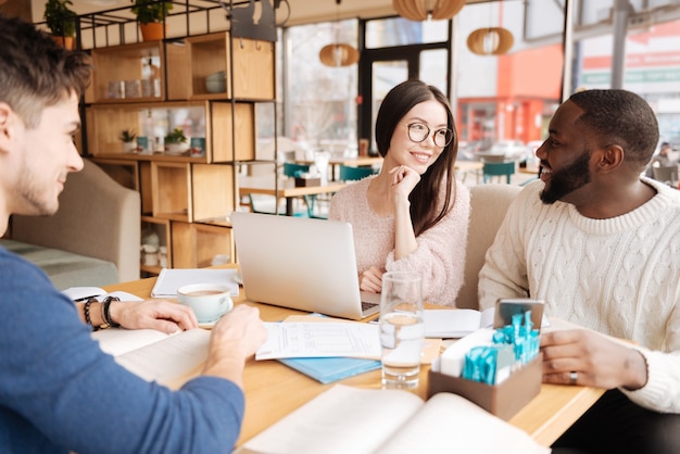 Aangename ontmoeting. Groep jonge internationale studenten studeren samen in cafetaria.