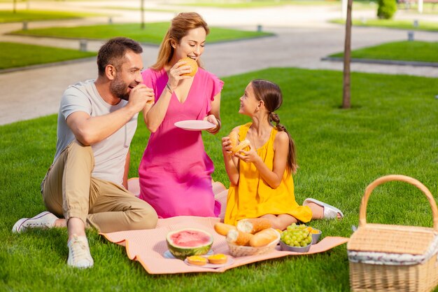 Aangename picknick. positieve verenigde familie met een picknick terwijl ze samen weekends doorbrengen