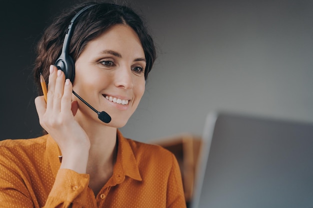 Aangename vrouw Spaans sprekende callcentermedewerker in draadloze headset in gesprek met klant