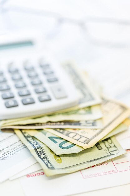 Aangifte inkomstenbelasting berekenen met gevouwen contant geld op een tafel.