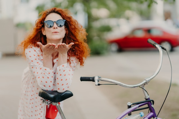 Aanhankelijk roodharige vrouw stuurt luchtkus naar geliefde op straat