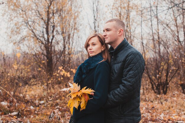 Aanhankelijke gezellige knuffels van een jong liefdevol stel in het herfstpark