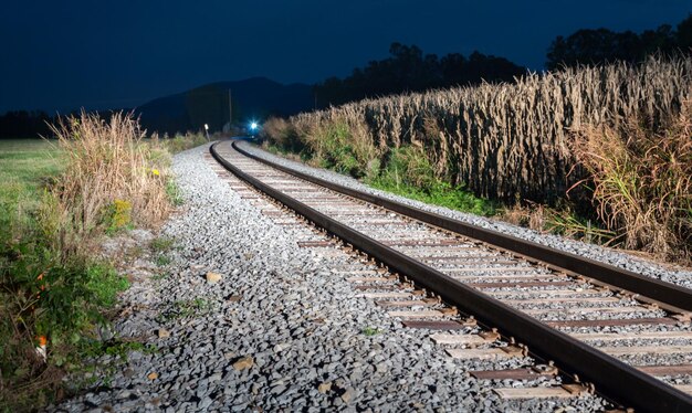 Foto aankomende trein 's nachts over steile sporen