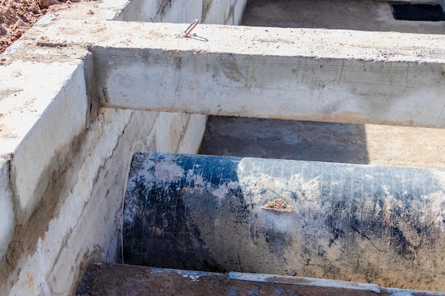 Aanleggen van ondergrondse leidingen in betonnen bak Installatie van waterleiding op de bouwplaats Aanleg van hemelwaterputten rioleringsklep sanitair en pompstation