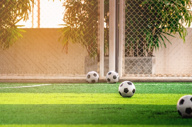 Aantal kinderen die voetbalballen op voetbaltrainingsveld trainen zonder mensen.