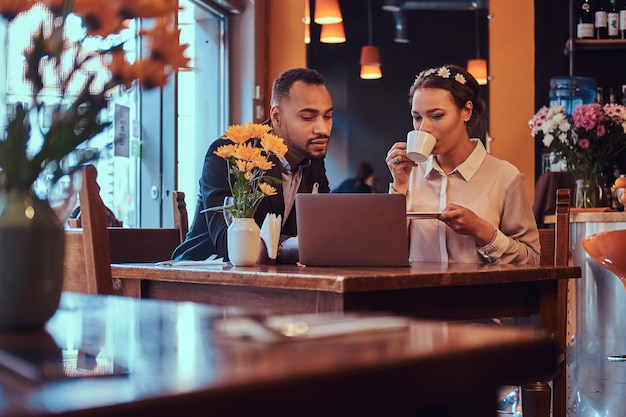 Aantrekkelijk Afrikaans-Amerikaans stel op een zakelijke bijeenkomst in een restaurant dat werkmomenten bespreekt met laptop tijdens de lunch.