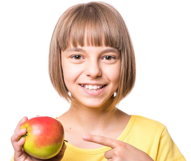 Aantrekkelijk blank meisje met appel geïsoleerd op witte achtergrond Schoolmeisje glimlachend en naar de camera kijkend Gelukkig kind met vers fruit emotioneel portret close-up