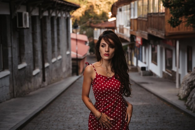 Aantrekkelijk brunette meisje met een sexy figuur poseert op een prachtige oude Europese straat met straatstenen
