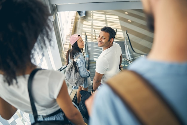 Aantrekkelijk en opgewonden divers interraciaal stel lacht terwijl ze op vakantie gaan