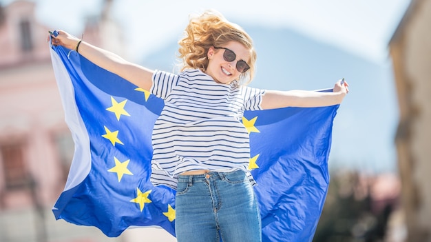 Foto aantrekkelijk gelukkig jong meisje met de vlag van de europese unie.