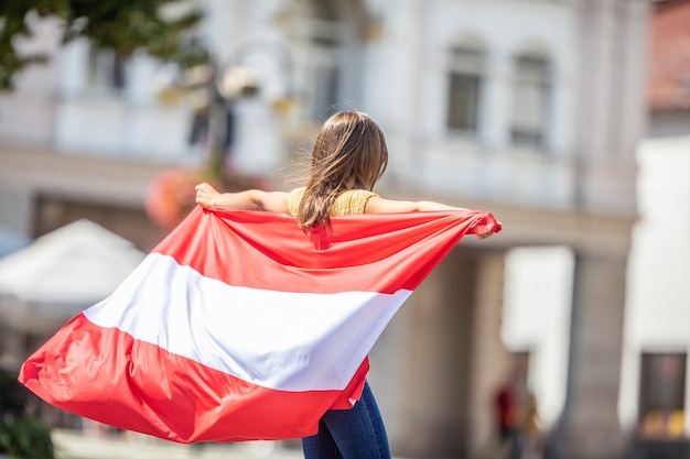 Aantrekkelijk gelukkig jong meisje met de vlag van Oostenrijk.