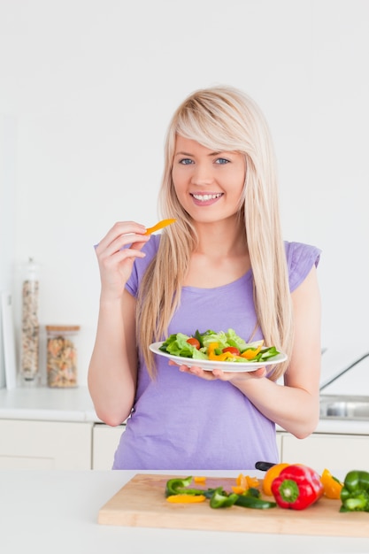 Aantrekkelijk glimlachend wijfje dat haar salade eet