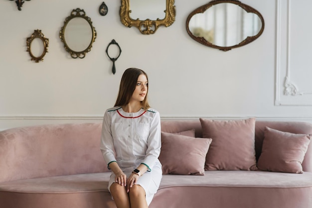 Aantrekkelijk jong meisje in een witte medische jurk in een prachtig interieur VIP-kliniek schoonheids- en ontspanningssalon