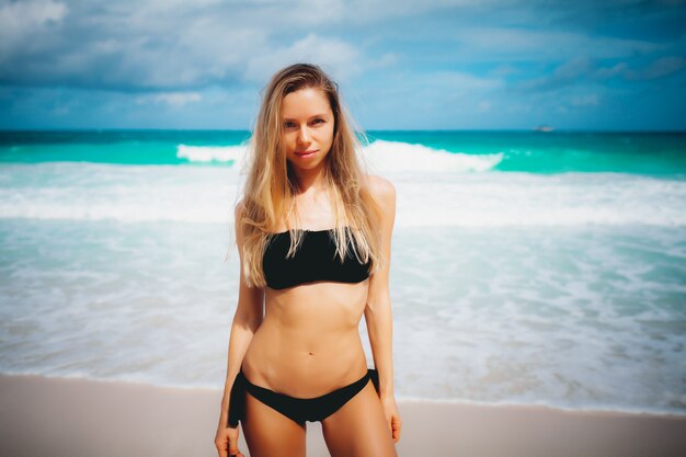 Aantrekkelijk Kaukasisch blondemeisje met perfect lichaam op het de zomerstrand van de blauwe lagune