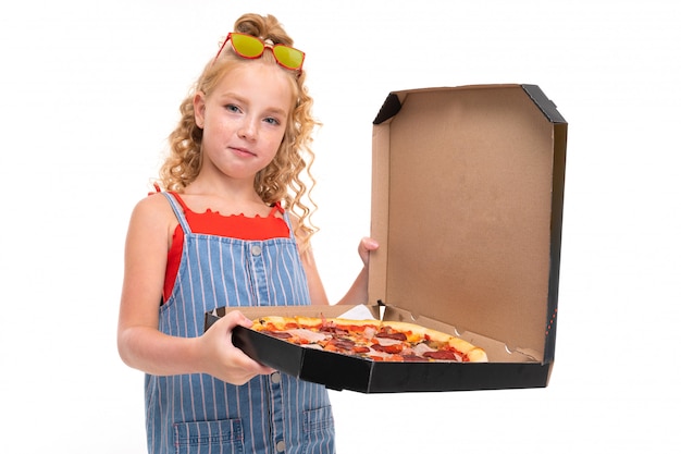 Aantrekkelijk meisje houdt een open doos met pizza op een wit