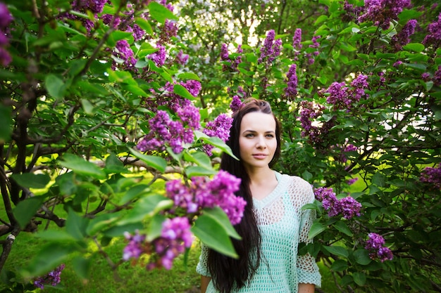 Aantrekkelijk meisje in het park tegen een bloeiende boom. Portret van een vrouw.