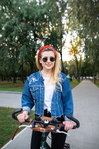 Aantrekkelijk meisje lopen op de fiets in het park